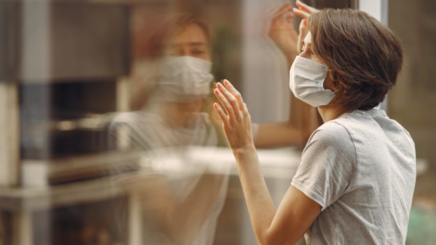 mujer-mascara-junto-ventana_1157-31618